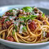 Steaming plates of Italian Drunken Noodles showcase sautéed shrimp, onions, and garlic tossed with noodles and a bold red wine reduction.