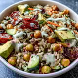 Hearty Simple Grain Bowl with quinoa, grilled chicken, cucumbers, carrots, and a lemony dressing drizzle.
