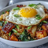 Steaming Korean fermented cabbage kimchi fried rice bowl, topped with a perfect sunny-side-up egg.