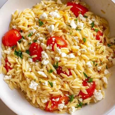 Freshly cooked orzo pasta tossed with crisp cucumber, cherry tomatoes, red onion, and salty feta cheese in a bright lemon dressing.