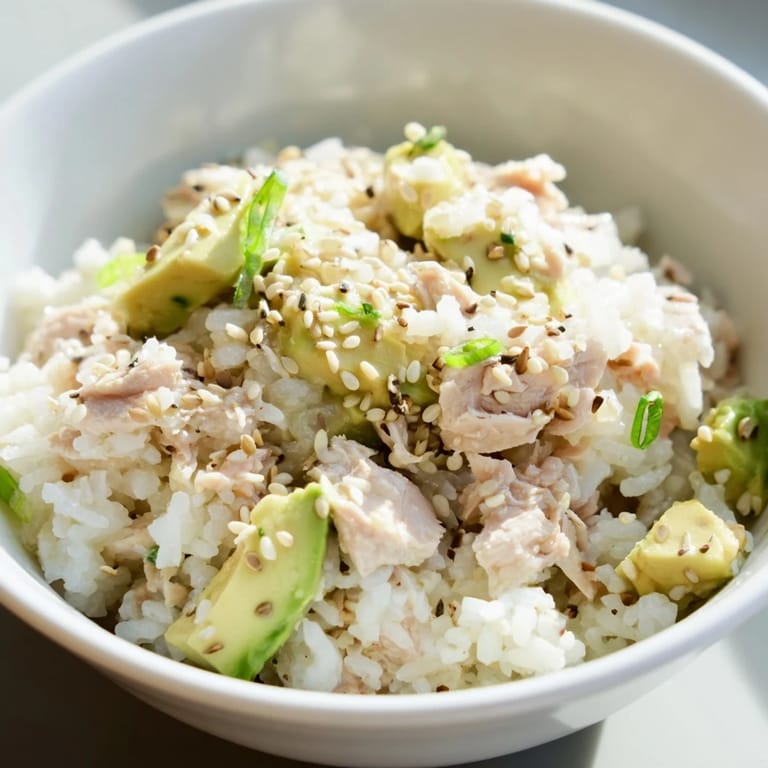 Ready in 30 minutes, this fusion Tuna Avocado Rice Bowl is garnished with nori and sesame seeds for a fresh, satisfying meal.