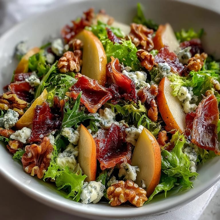 Ripe pear slices and creamy blue cheese top the frisée, pear, blue cheese, and crispy prosciutto salad on a rustic platter.