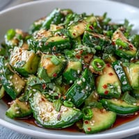 Vibrant smashed cucumber avocado salad with toasted sesame seeds, a light, refreshing side.
